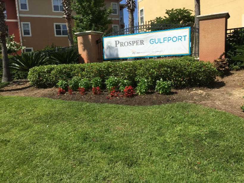 Maintained landscape and entrance at a Gulf Coast apartment community